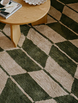 Living room scene with a moss green and beige chevron-patterned rug by Broste Copenhagen