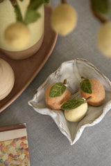 Lifestyle image of vase containing felt lemon branch with felt lemons in foreground