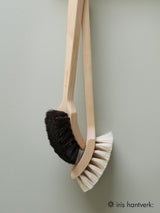 Two wooden cleaning brushes with black and white bristles on a light gray background, branded 'iris hantverk'.