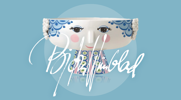 Björn Wiinblad signature over image of Eva ceramic bowl with characteristic rosy-cheeked lady design in blue and white - Danish folk art inspired homeware