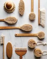 selection of Iris Hantverk bath & kitchen brushes on a marble background