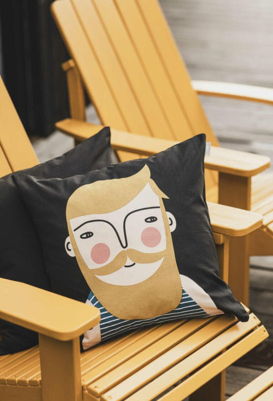 Spira of Sweden Frank cushion with a illustration of a man's face on a wooden deckchair