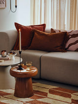 living room scene including A rectangular rug by Broste Copenhagen with a geometric chevron pattern in terracotta orange and cream