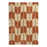 A rectangular rug by Broste Copenhagen with a geometric chevron pattern in terracotta orange and cream, shown flat against a white background.