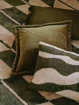 Green textured pillows on a patterned rug