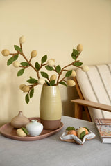 Lifestyle image of vase containing felt lemon branch