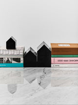 set of three black glass houses by kosta boda used as bookends