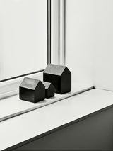 row of three black glass houses by Kosta Boda Sweden on window ledge