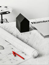 black glass house by kosta boda sweden used as paper weight on desk