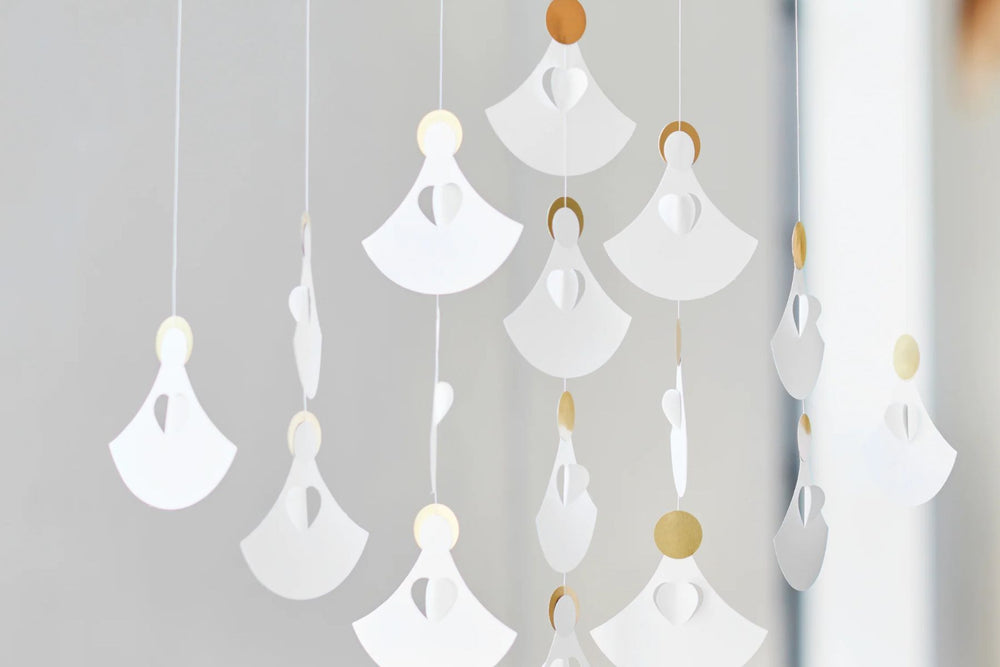 Decorative hanging Flensted angel choir mobile with white and gold elements on a light gray background, available from The Scandinavian Shop