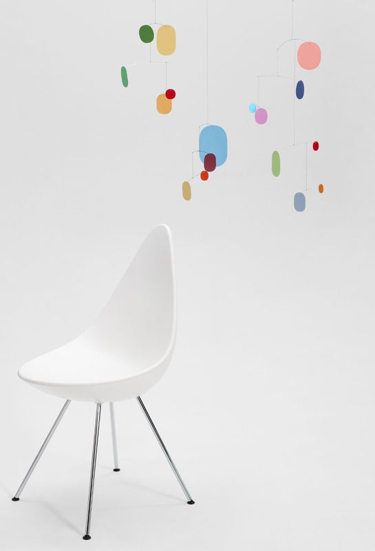 Flensted Mobiles colourful UN17 Balance mobile next to a white chair