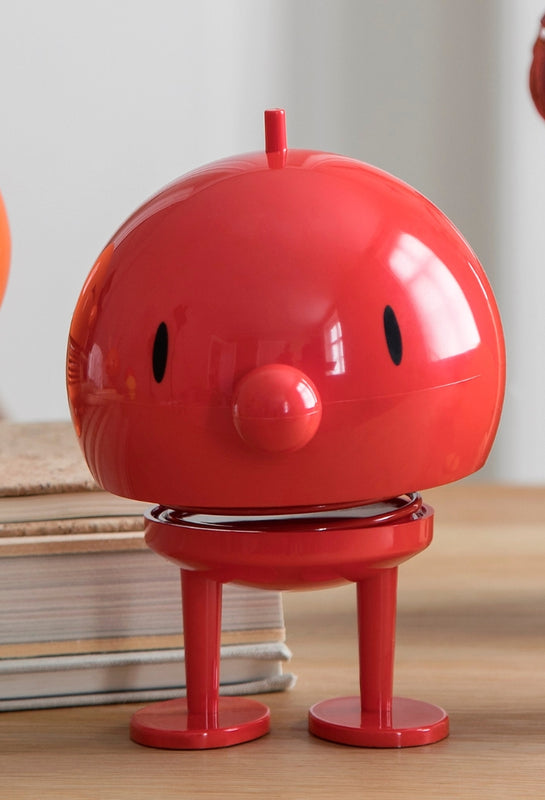 Red Hoptimist Bumble figurine, from The Scandinavian Shop, on a wooden desktop